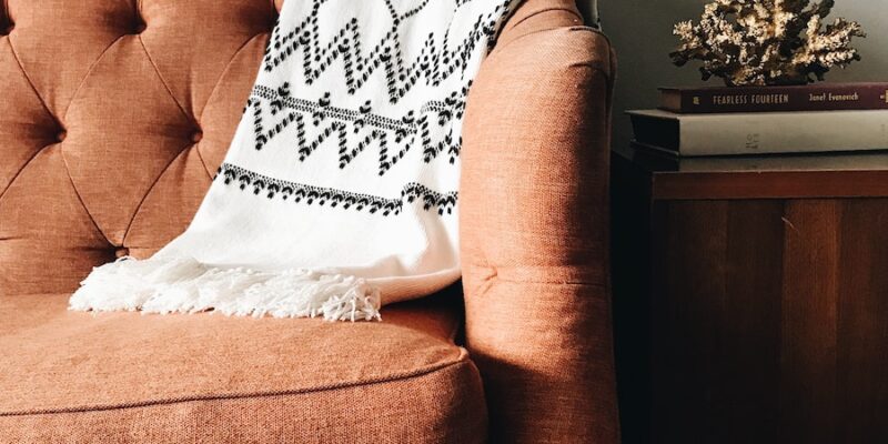 white and black textile on brown couch